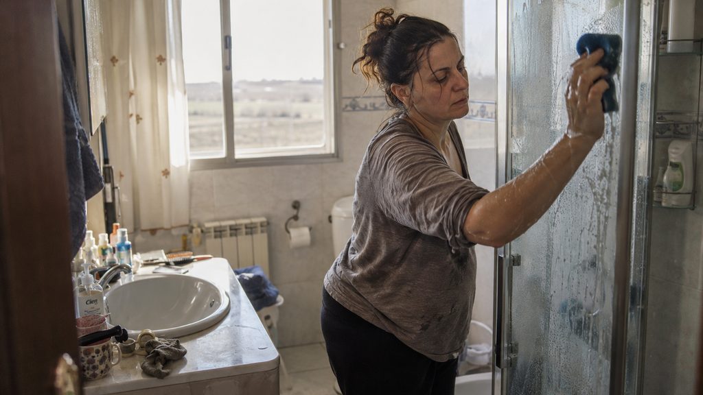 Empleada de hogar trabajando en el baño en una vivienda de Albacete