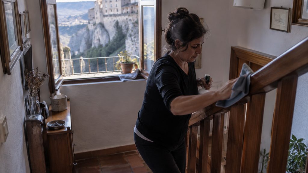 Empleada de hogar trabajando en la escalera interior en una vivienda de Cuenca