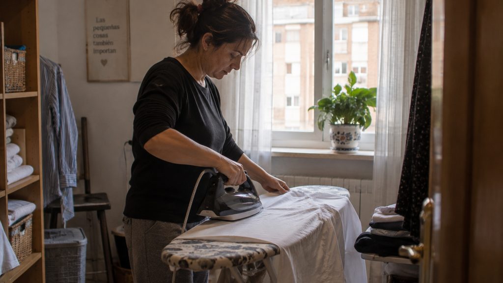 Empleada de hogar trabajando en el cuarto de la plancha en una vivienda de Palencia
