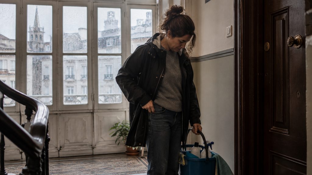 Trabajadora de limpieza en un descansillo durante su jornada en A Coruña