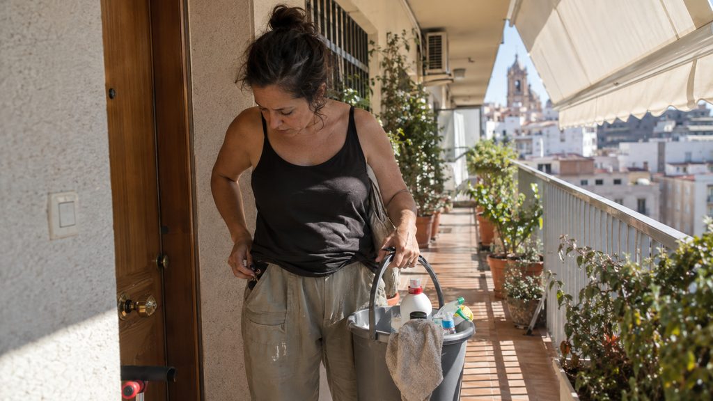 Trabajadora de limpieza en un descansillo durante su jornada en Málaga