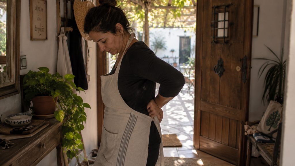 Trabajadora de limpieza en una entrada de casa durante su jornada en Murcia